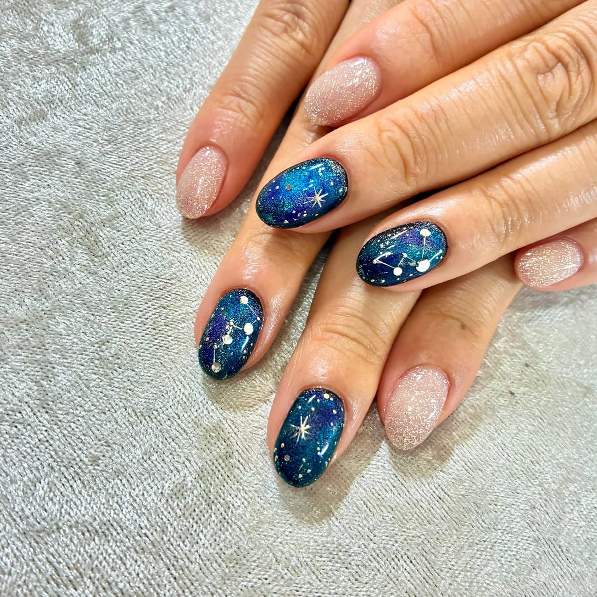 夜空のような深いブルーに星や星座を描いたギャラクシー風ジェルネイル
